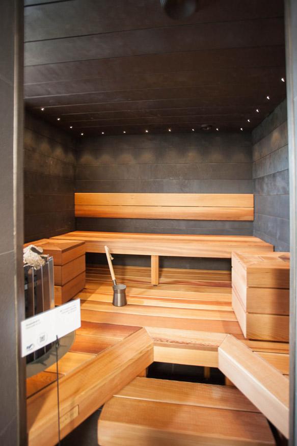 Myös tässä saunassa on käytetty jättiläistuijaa. Lämminsävyisen tuijan parina on mustaksi maalatut seinäpaneelit.