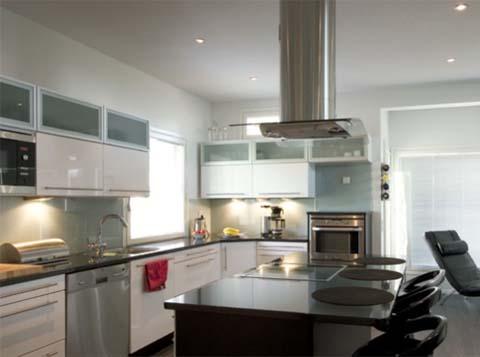 Toimiva keittiö on rakentunut modernisti liesisaarekkeen ympärille.