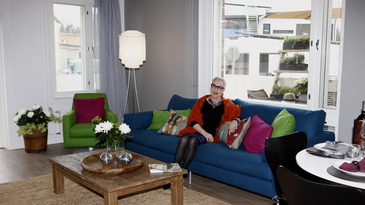 Meikkitaiteilija Raili Hulkkonen valitsi olohuoneeseen kirkkaan värisen sohvan ja nojatuolin. Neutraalit seinät korostavat upeita värejä.