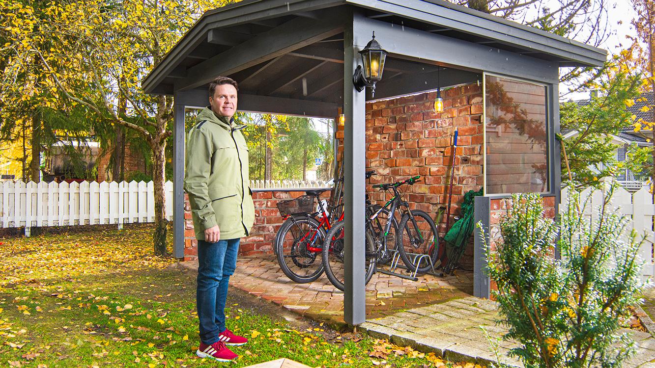 Tamperelainen Konsta Takala esittelee tyytyväisenä uutta pyöräkatosta, jonka alla viisihenkisen perheen kulkupelit pysyvät järjestyksessä. (Kuva: Panu Pitkänen)