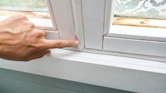 sormi osoittaa ikkunan raossa olevaa ikkunatiivistettä