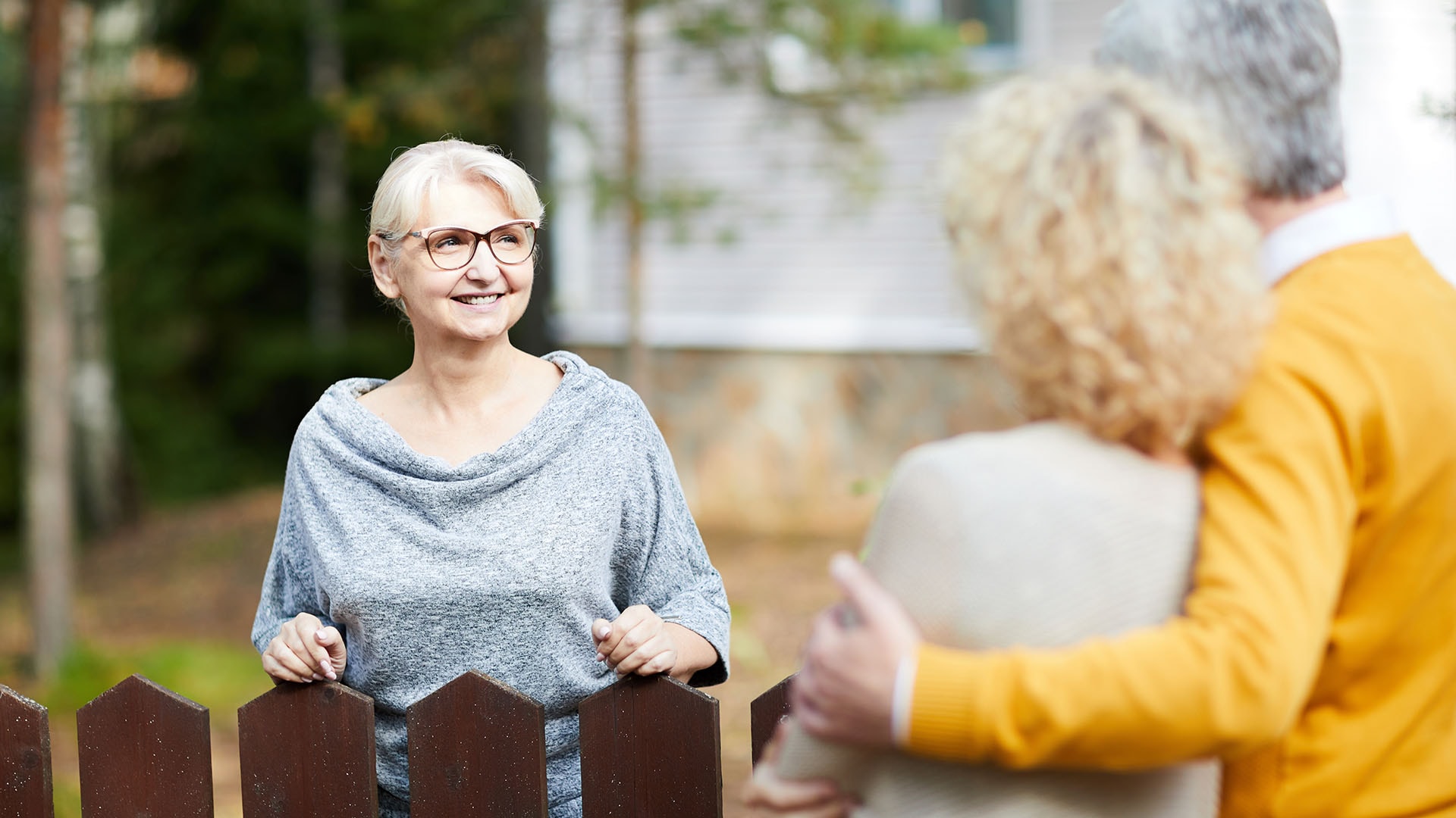 1920 naapurit tapaavat toisiaan punertavanruskean aidan yli