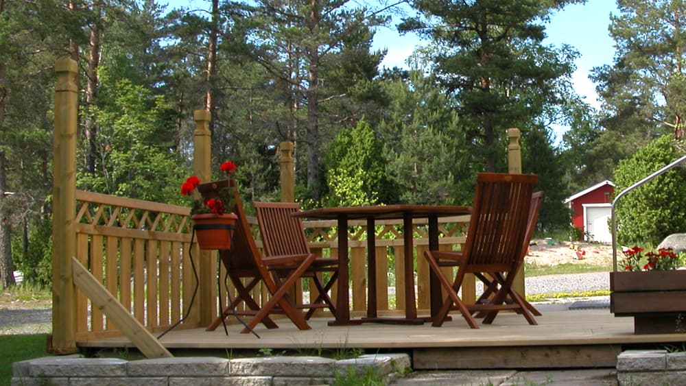 <p data-block-key="onwyq">Vasemmalla näkyy tilapäinen vinotuki. Avonaiseen reunaan on tarkoitus myöhemmin rakentaa köynnösristikot, joiden väliin jää kulkuaukko. Etualalla näkyvät muurikivet, jotka tältä sivulta tulevat yli terassin. Laudoituksen ja muurikivien väliin jää tilaa tulevien villiviinien istuttamista varten.</p>